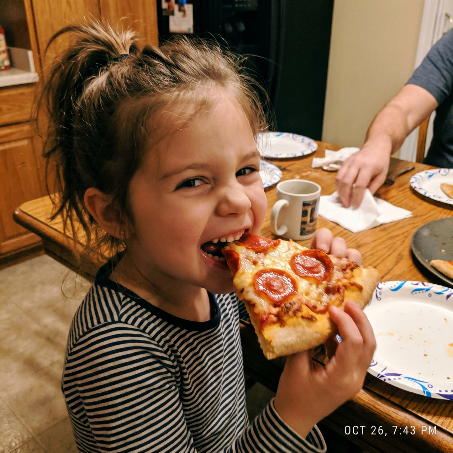 A child taking a big bite of home-made pepperoni pizza